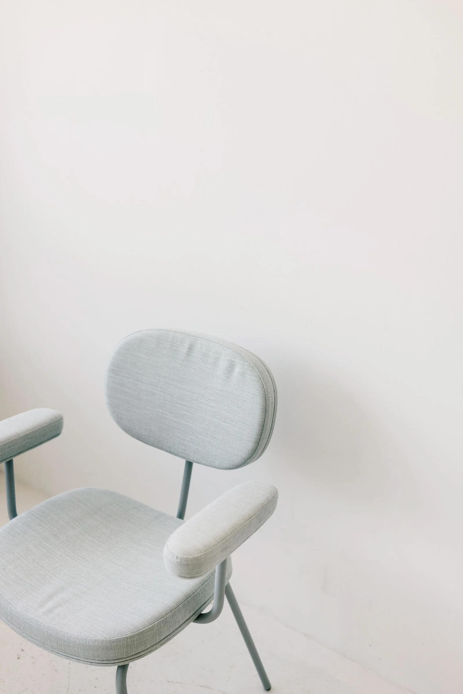 Grey fabric armchair in a minimalist room, the kind of upholstery you can recolor with fabric paint