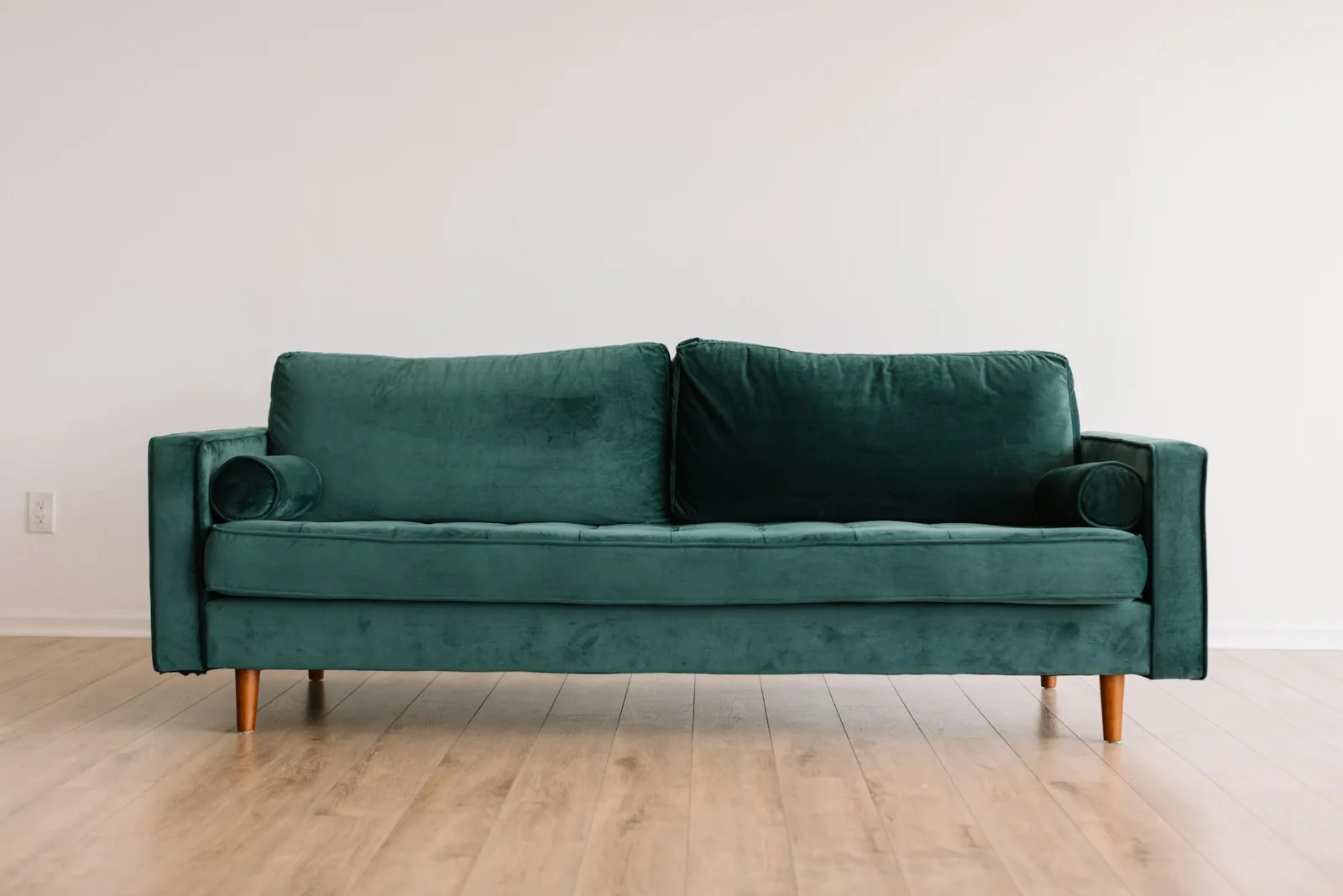 Green fabric sofa in a bright room, the kind of upholstery a portable upholstery cleaner machine is used on