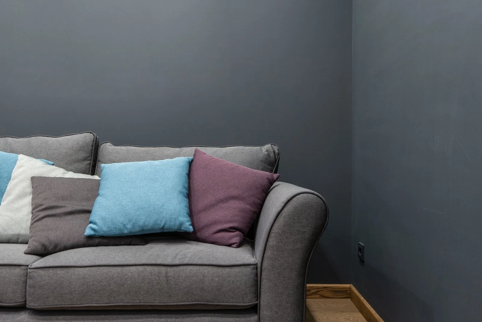 Gray sofa with colorful cushions, the kind of seat that benefits from a couch cushion support board